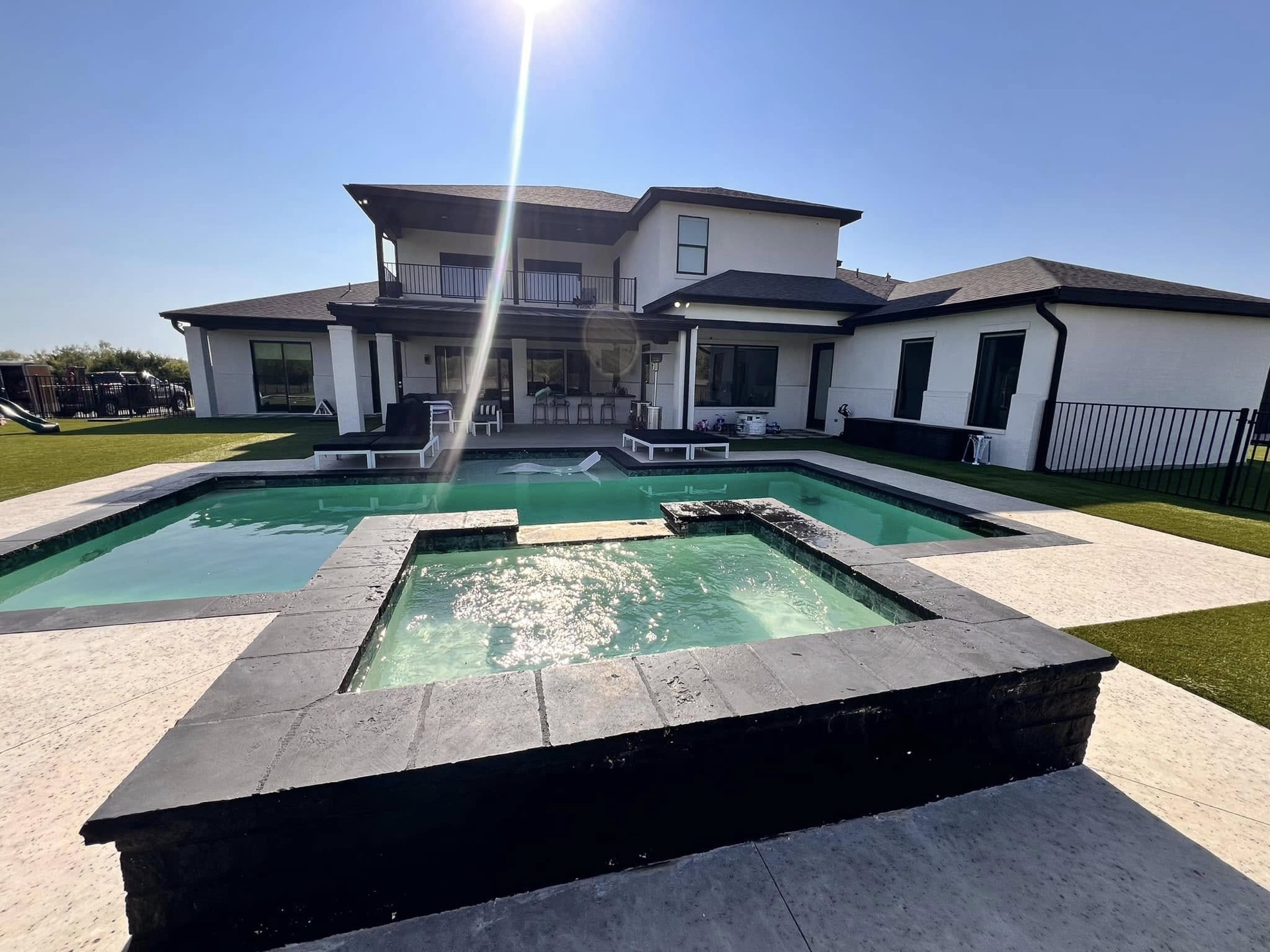 Custom geometric pool and raised spa built by Carrasco Pools behind a modern West Texas home