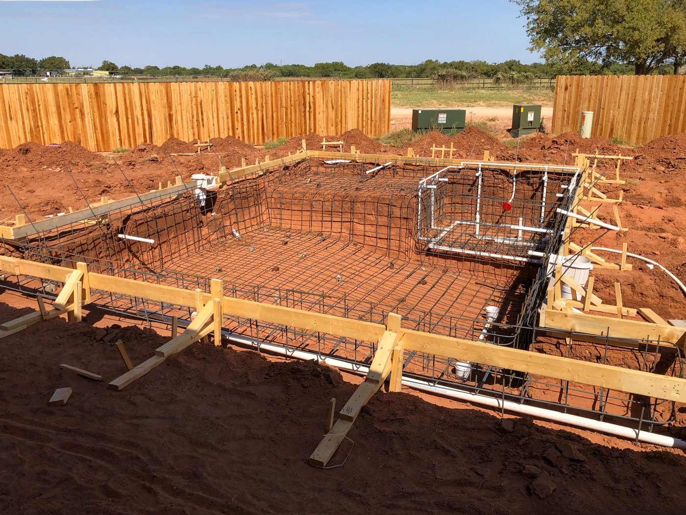 Rebar grid and wood forms set across a new pool shell, ready for gunite