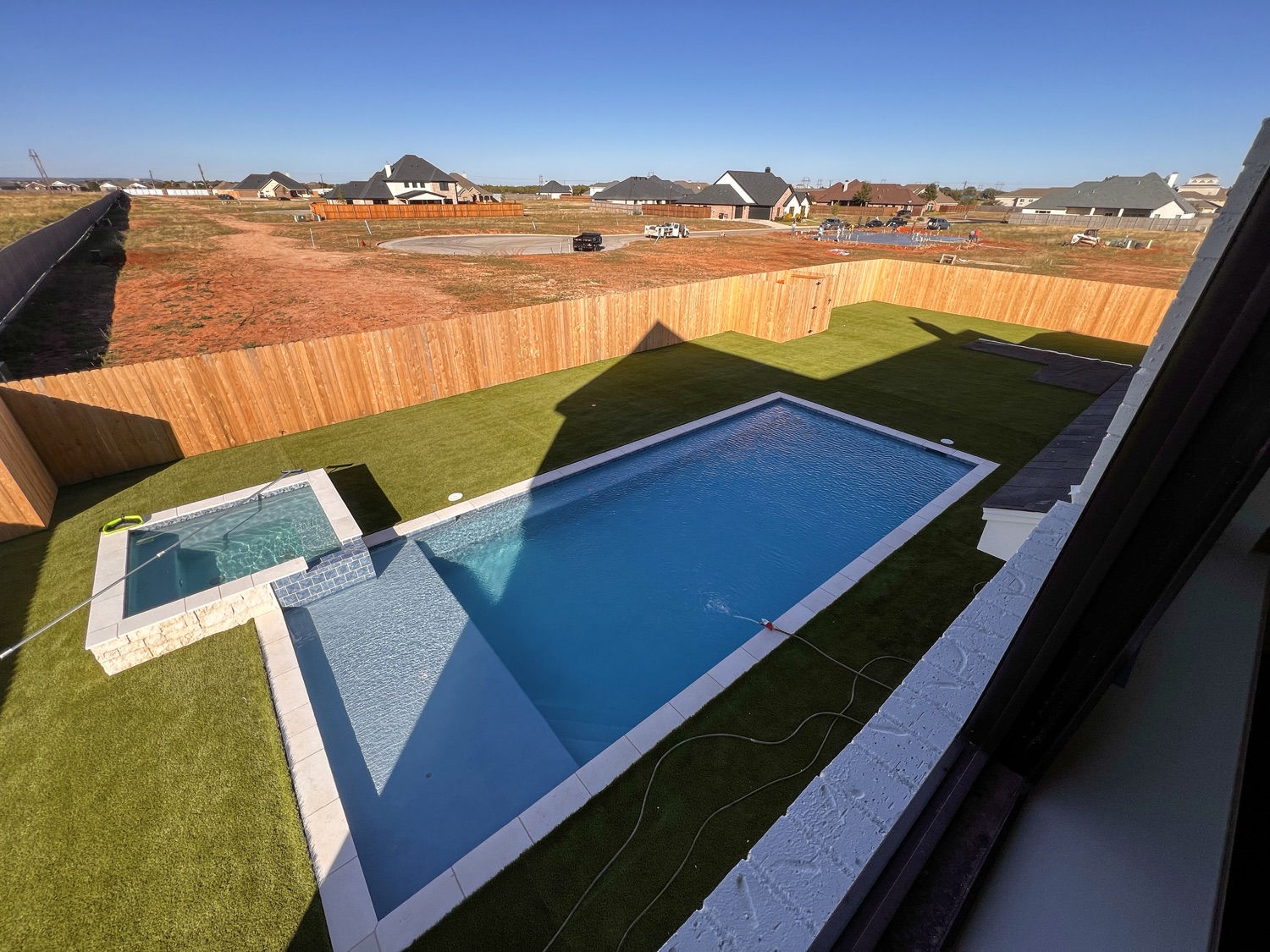 Elevated view of a finished geometric pool and raised spa