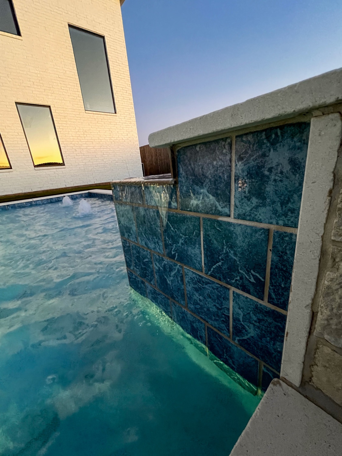 Close view of a blue porcelain-tile spillway wall on the spa