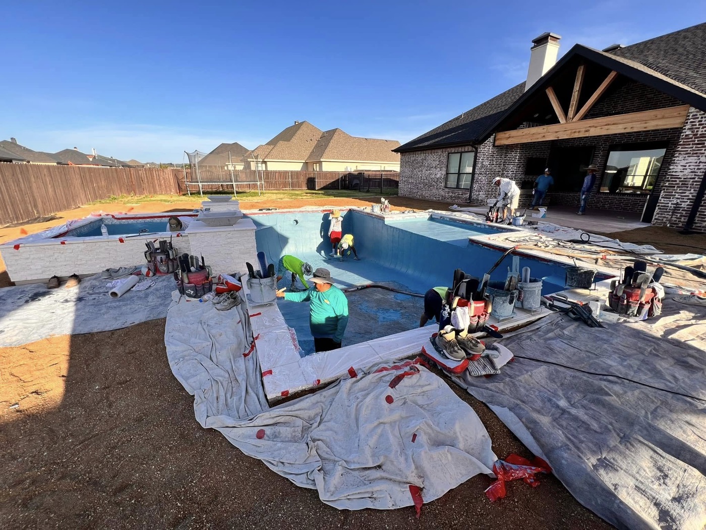 Carrasco Pools crew applying plaster finish to a pool and spa